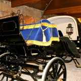 La carrozza reale con un manto di velluto blu e dorato che avvolge il sedile del cocchiere